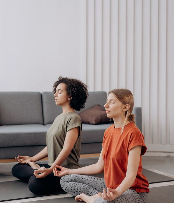 Person in a calm yoga pose in a minimalist dark room.